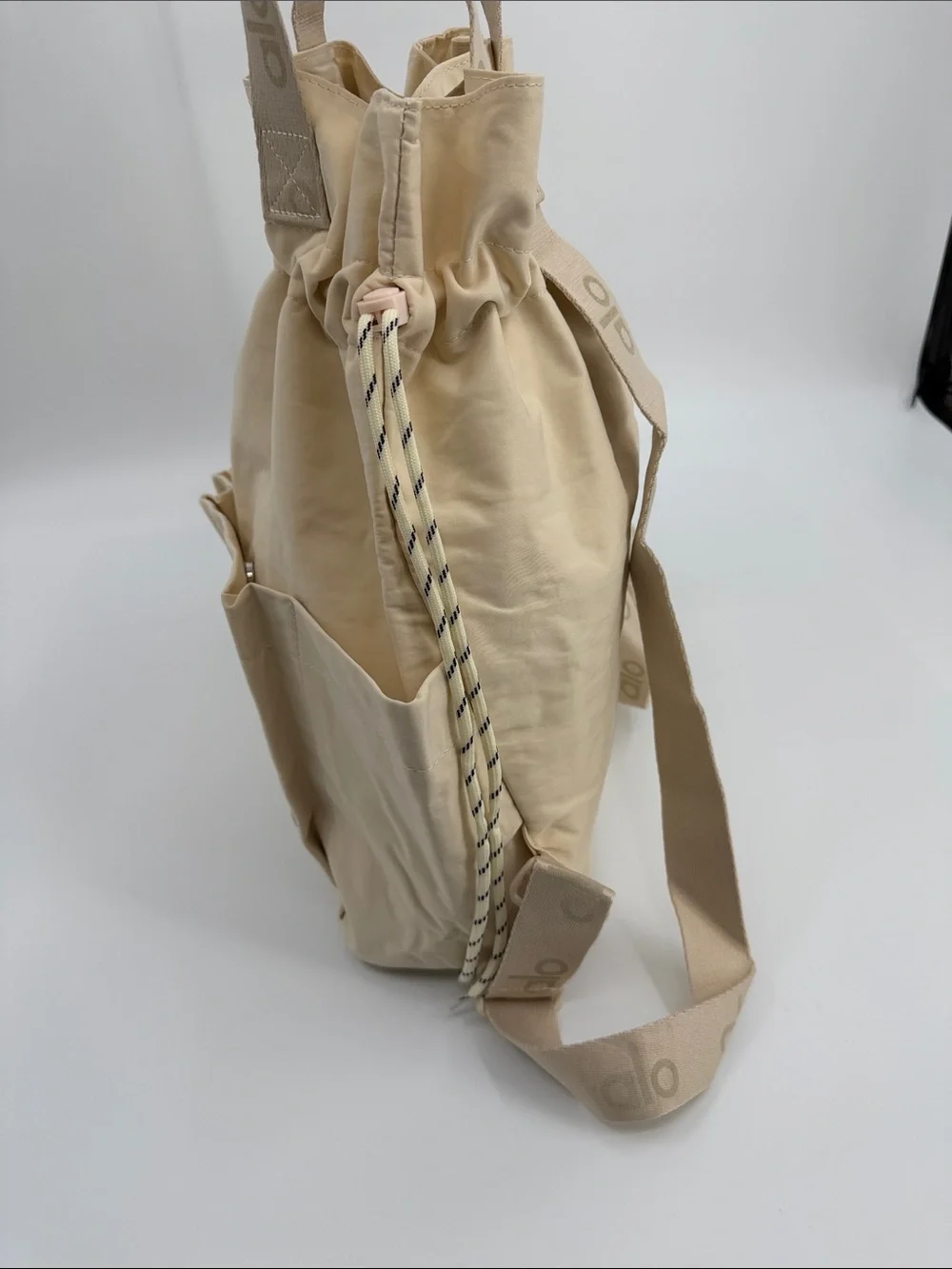 ALO Yoga Cream Drawstring Tote Backpack with Front Pockets Convertible Tote Bag